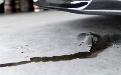 Oil puddle on the floor beneath a car.
